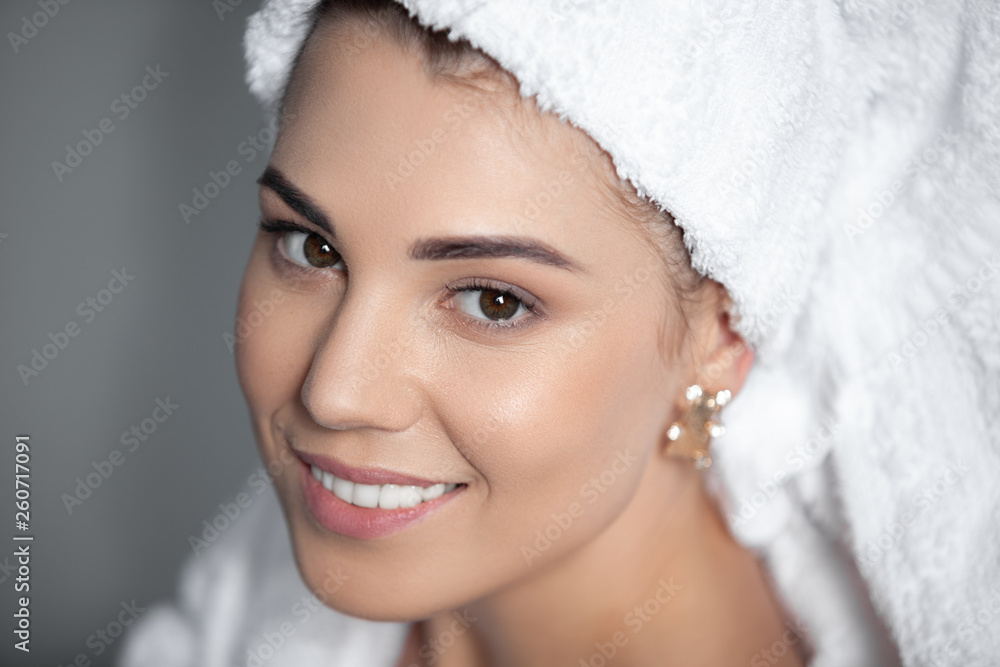 Attractive girl wearing white towel on head and white bath robe, smiling Attractive girl wearing white towel on head and white bath robe, smiling