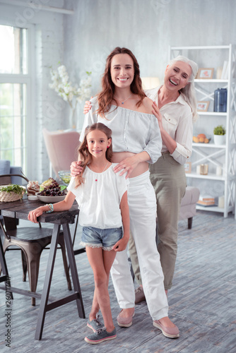 Pregnant woman feeling cheerful standing near daughter and mother