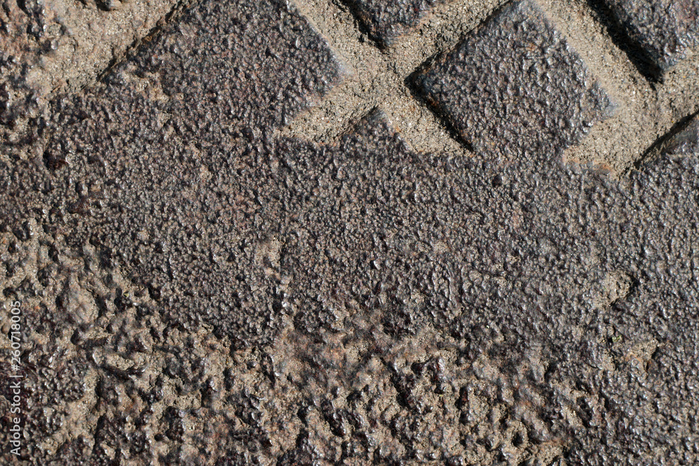 Fragment of rough metal surface. Close-up of old cast-iron manhole Fragment of rough metal surface. Close-up of old cast-iron manhole