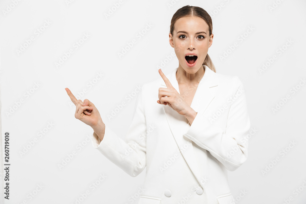 Photo of caucasian businesswoman pointing fingers aside at copyspace with surprise isolated over white background Photo of caucasian businesswoman pointing fingers aside at copyspace with surprise isolated over white background