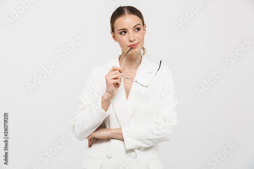 Photo of happy businesswoman 20s wearing elegant jacket looking aside and holding eyeglasses