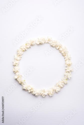 Jasminum sambac or Mogra Flower arranged in a circular or rectangular frame shape over white background, selective focus