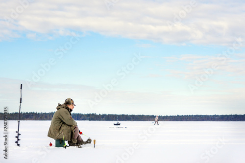 man catches a fish in the winter