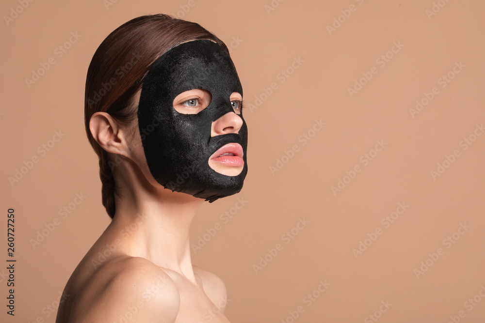 Woman with black mask on the face thoughtfully looking away Woman with black mask on the face thoughtfully looking away