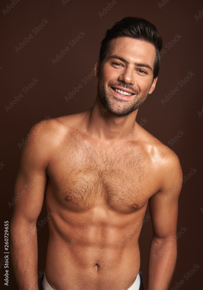 Happy topless muscular man posing on camera