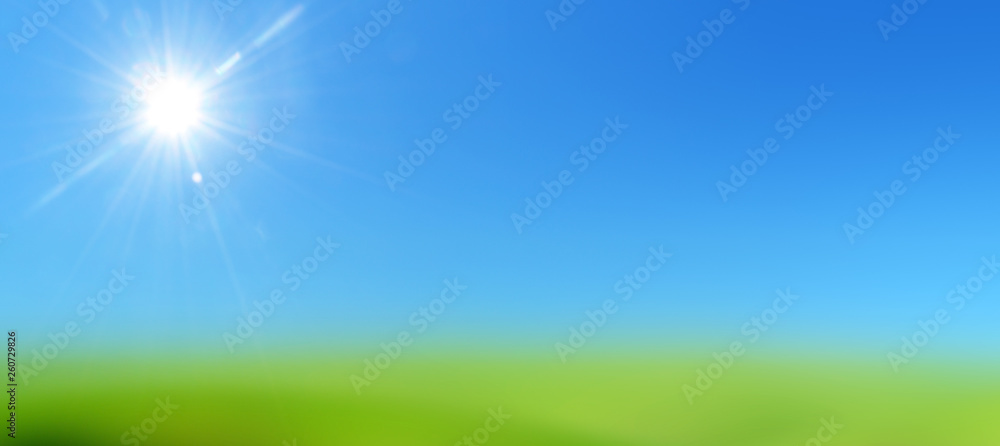 blue sky with sun on a lawn of green grass 