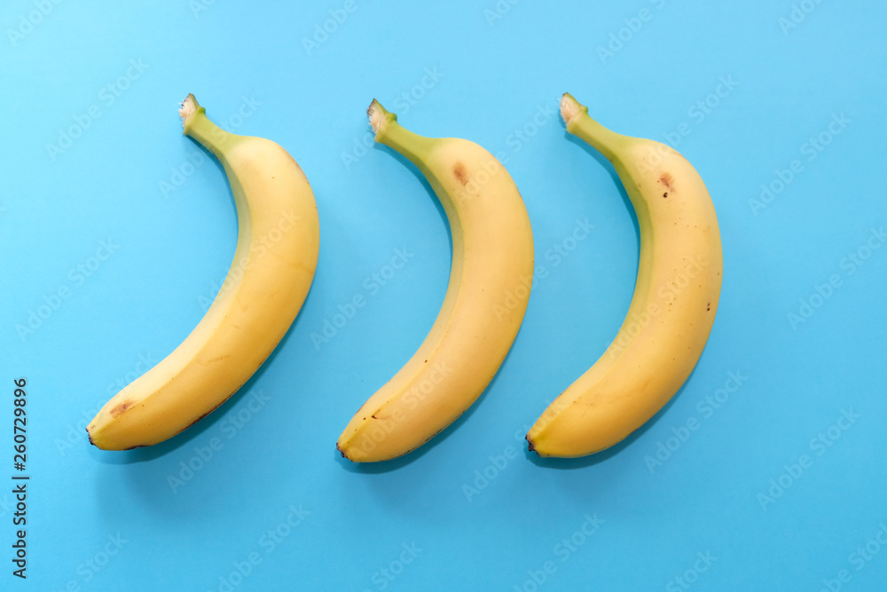 Three bananas on a blue background, top view Three bananas on a blue background, top view