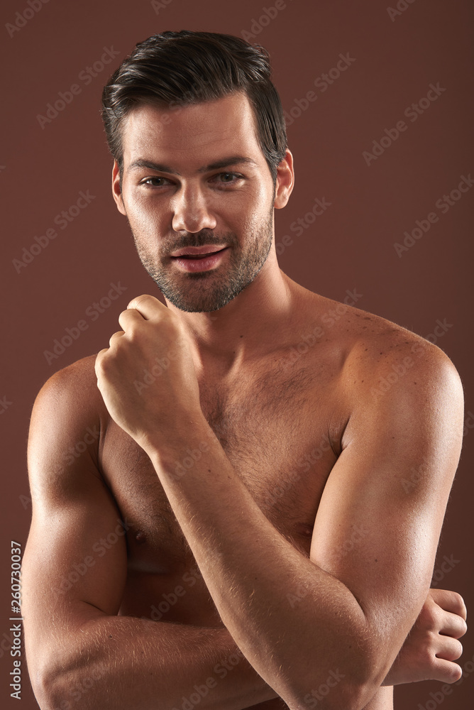 Fototapeta premium Smiling topless muscular man posing on camera