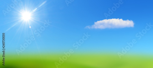 blue sky with sun and clouds on a lawn of green grass