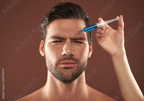 Young manful guy have forehead filler injection