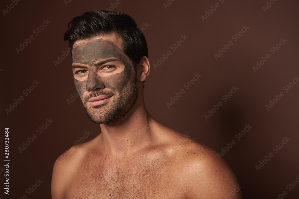 Young manful self-confident guy with face mask