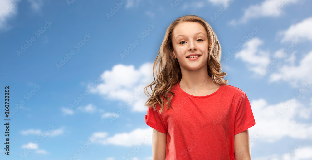 people concept - smiling teenage girl with long hair in red t-shirt over blue sky and clouds background people concept - smiling teenage girl with long hair in red t-shirt over blue sky and clouds background
