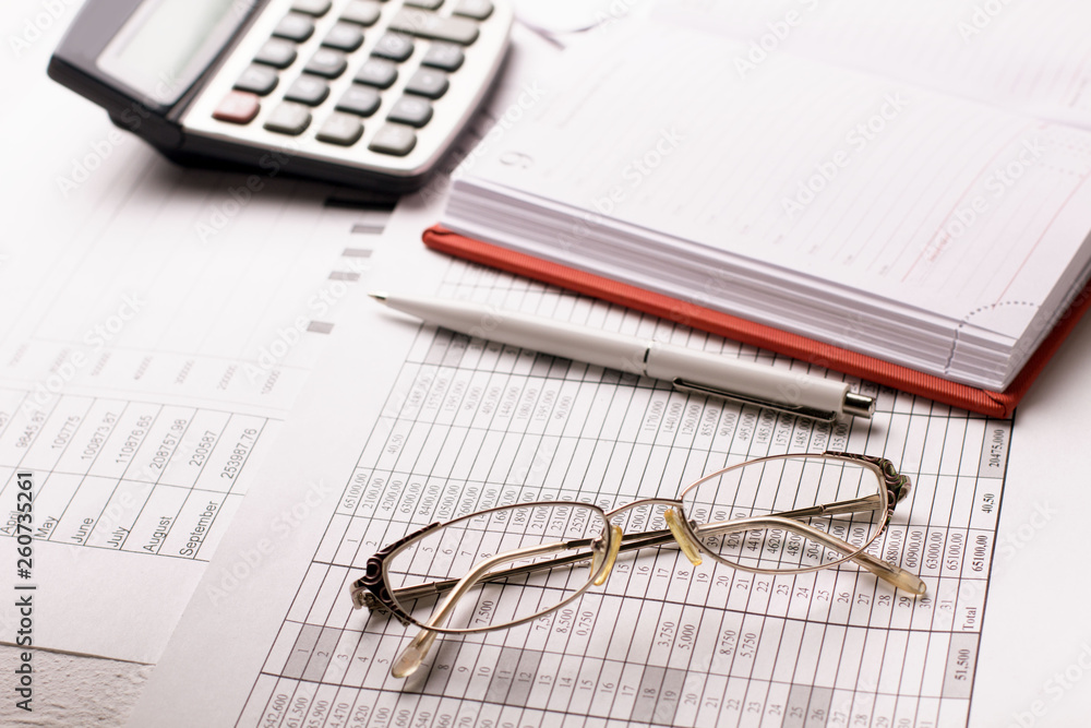 Accountant work table with calculator, charts and pen. Accountant work table with calculator, charts and pen.