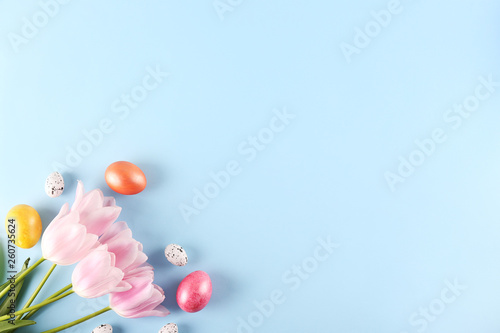 Bunch of hand painted Easter eggs of different pastel glossy color on bright paper background with a lot of copy space for text. Top view  flat lay  close up. Easter greeting card concept.