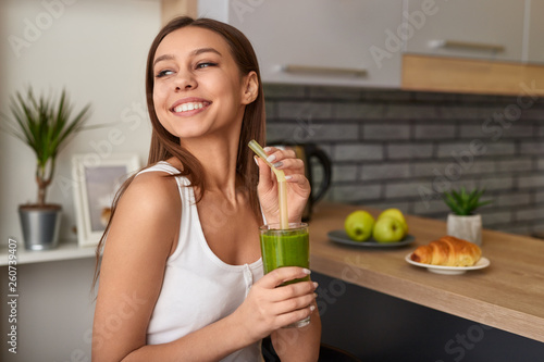 Tableau sur toile Cheerful woman enjoying detox smoothie