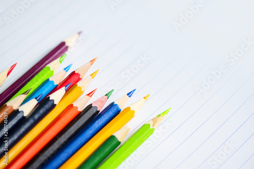 Colored pencil set on white paper notebook back to school and education concept / Crayons colorful