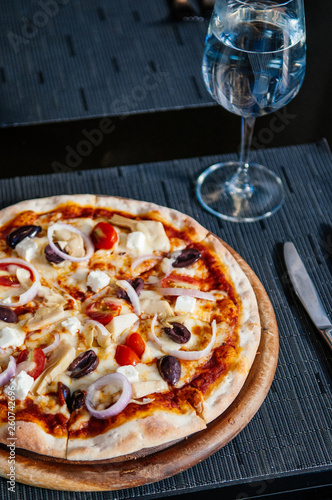 Italian pizza with olives, shallots and tomatoes
