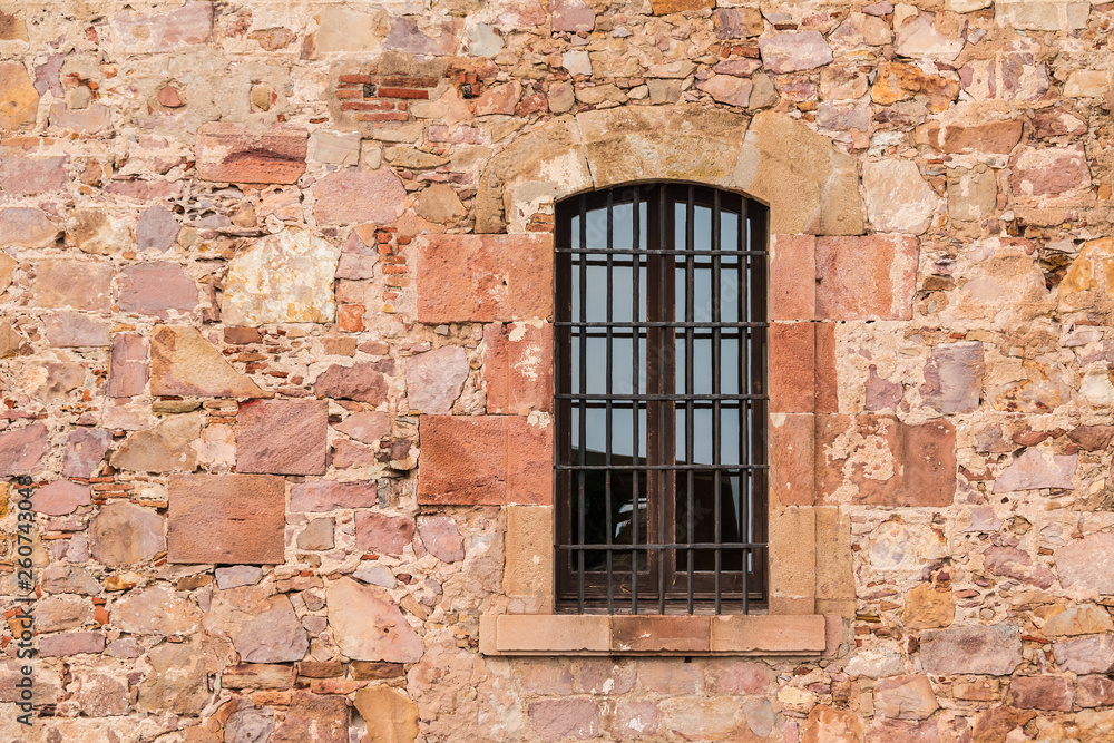 A window on the stone facade of the Montjuic Castle front view, Barcelona, Spain