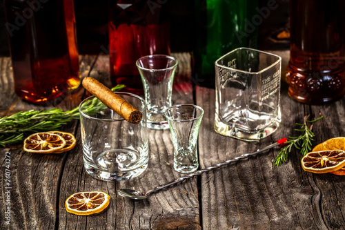 Selection of strong alcoholic drinks, glasses and shot glass in assortent: vodka, rum, cognac, tequila, brandy and whiskey. Dark vintage background, selective focus, copy space