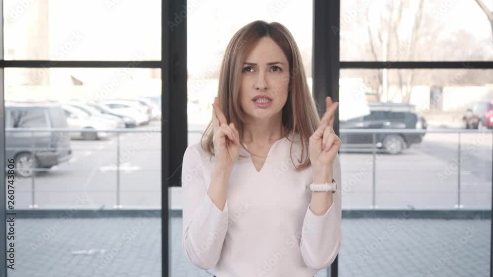 attractive worried woman with fingers crossed clapping hands before job interview attractive worried woman with fingers crossed clapping hands before job interview