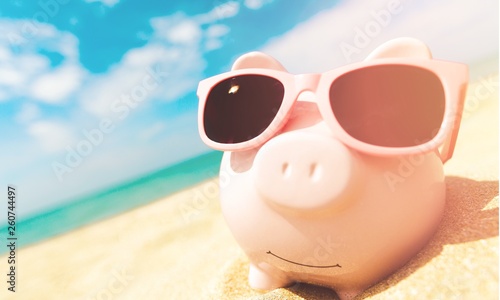 Piggy Bank Wearing Sunglasses Relaxing At The Beach © BillionPhotos.com