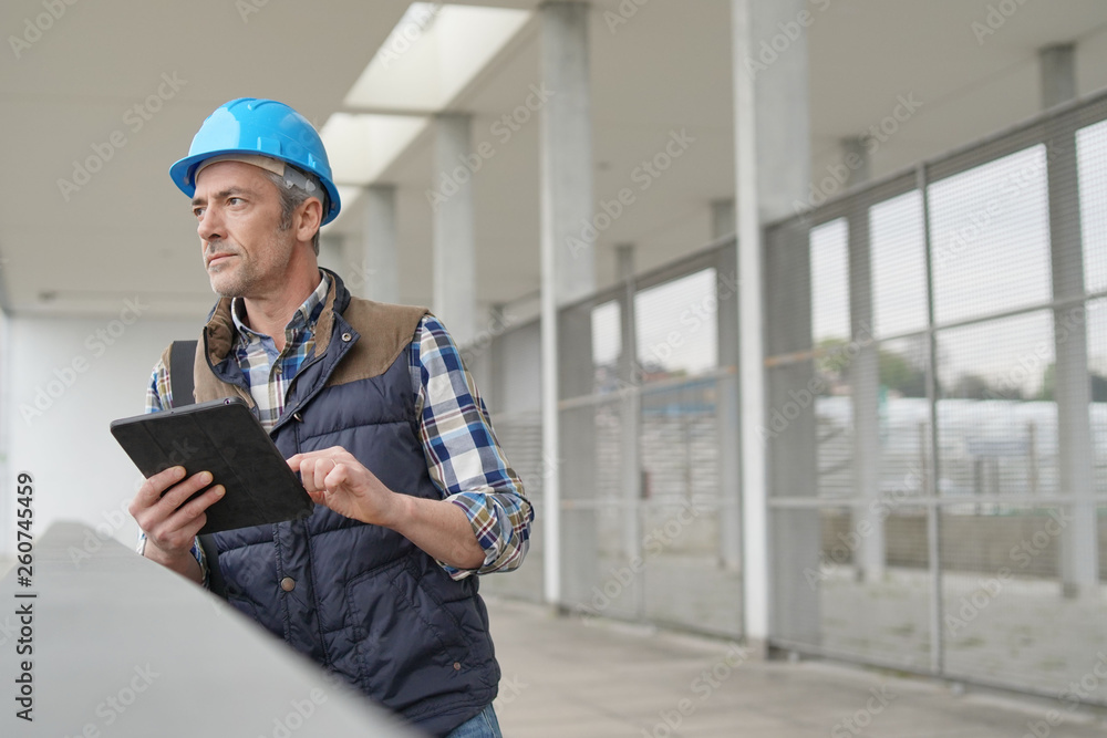 Lead architect checking work sight with tablet Lead architect checking work sight with tablet