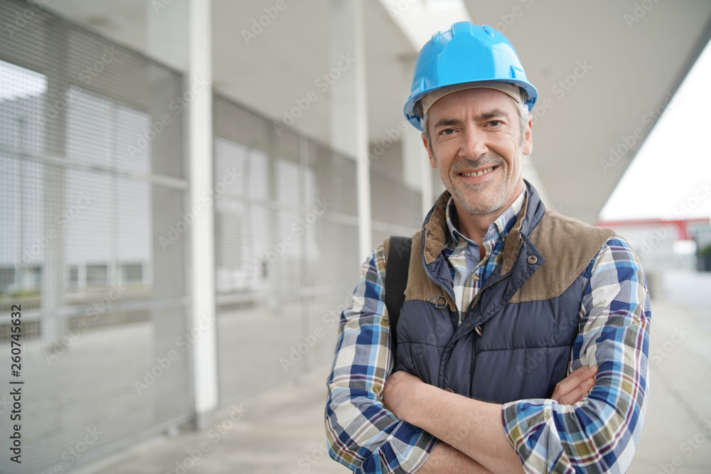 Construction worker looking at camera outside contemporary building Construction worker looking at camera outside contemporary building