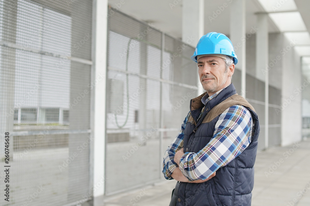 Construction worker looking at camera outside contemporary building