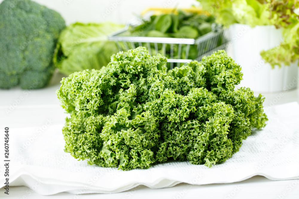 Heap of fresh kale leaves. Green vegetables on white background. Healthy eating concept. Heap of fresh kale leaves. Green vegetables on white background. Healthy eating concept.
