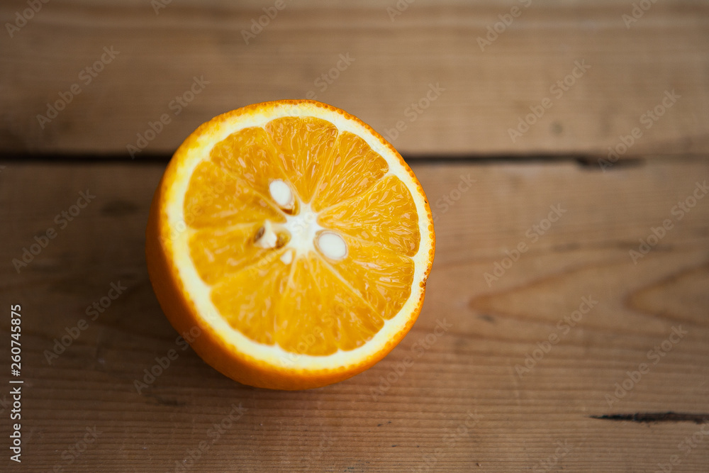 Half of orange on the wood background Half of orange on the wood background