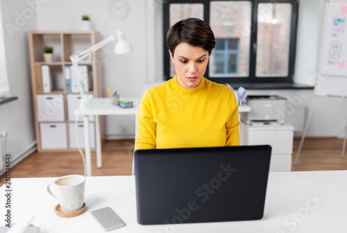 business, technology and people concept - businesswoman with laptop computer working at office