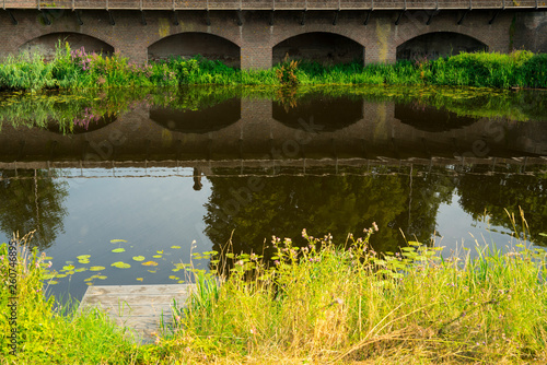 jetty and bridge, reflection in water in nature park Bossche Broek in Den Bosch, 's Hertogenbosch, The Netherlands
