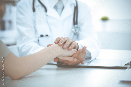 Hand of doctor reassuring her female patient. Medicine and health care concept