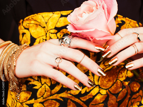 woman hands with golden manicure lot of jewelry on fancy dress close up beauty concept photo