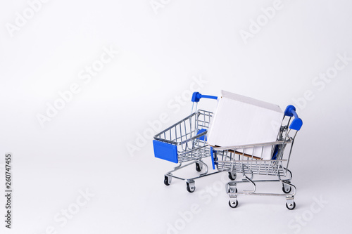 Empty miniature trolley from a supermarket on a white background.