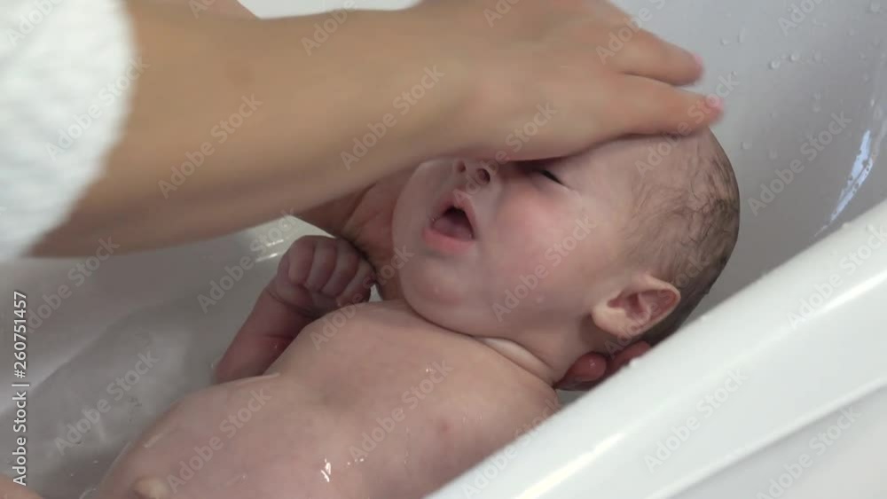 Mother take a bath for his newborn baby. Baby bath time Mother take a bath for his newborn baby. Baby bath time