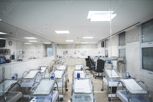 Maternity room in hospital and empty cribs of children lined up photo