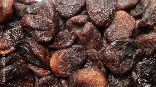 Brown dark color dried apricots as natural food background. Top view. Healthy food. Organic fruit not treated with sulfur dioxide photo