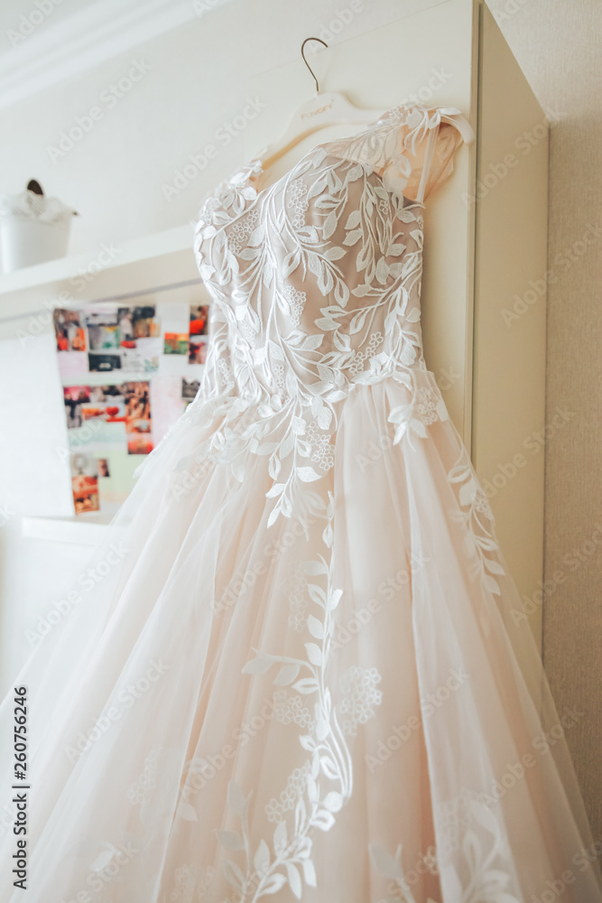 beautiful wedding dress hanging on a hanger in the room of the bride beautiful wedding dress hanging on a hanger in the room of the bride