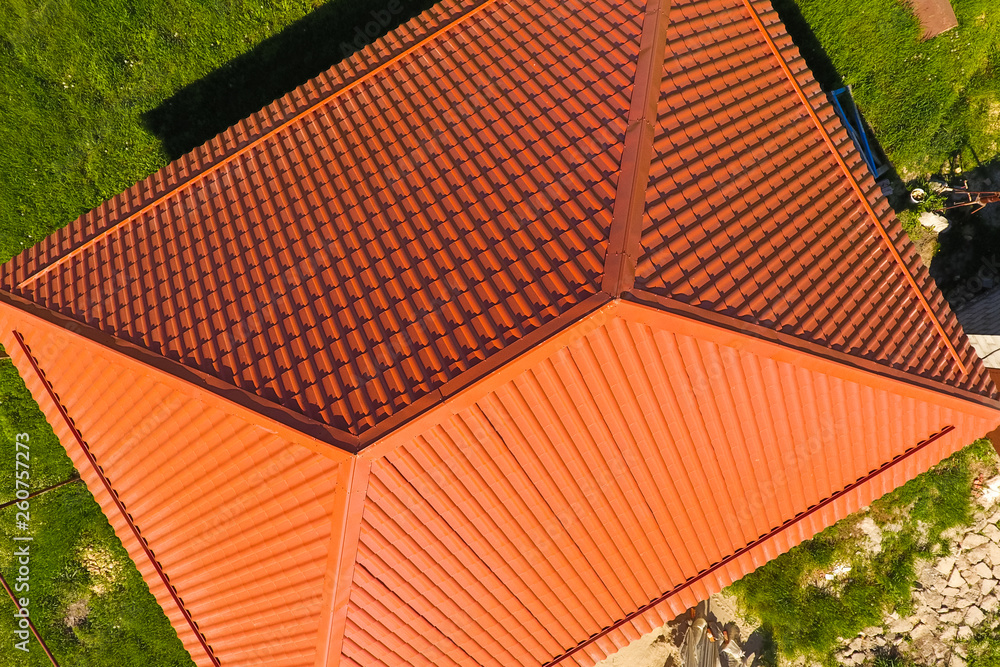 Naklejka premium House with an orange roof made of metal, top view. Metallic profile painted corrugated on the roof.