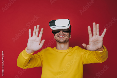 Low angle of smiling man touching something while situating in virtual reality
