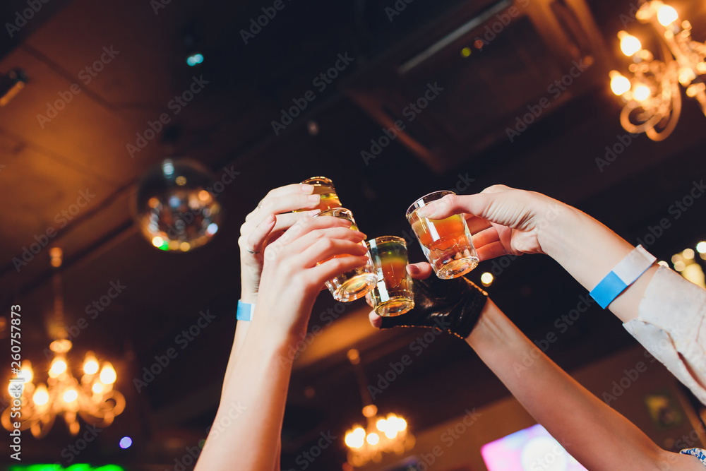Hand holding a glass shot with vodka shot. - obrazy, fototapety, plakaty 
