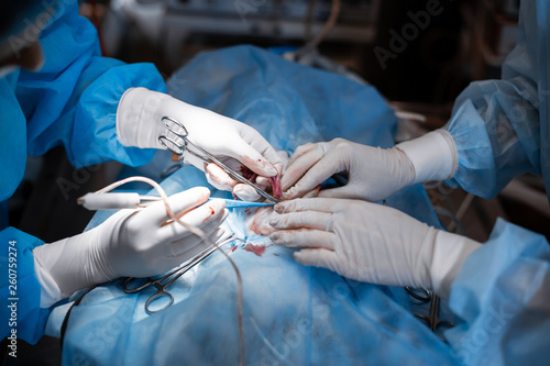 Closeup surgeon hands in bit bloody white gloves make operation