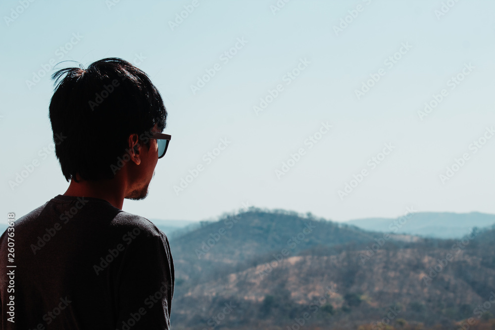 Man wearing sunglasses looking at the mountains Man wearing sunglasses looking at the mountains