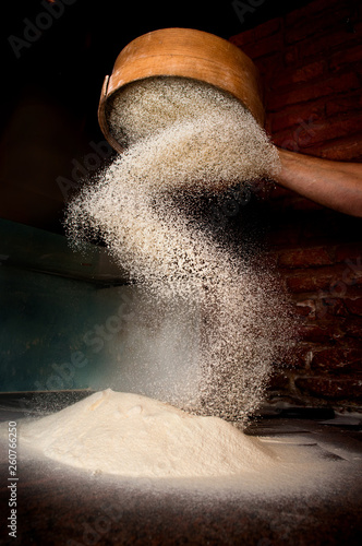 Canvas-taulu Sifting flour from old sieve.