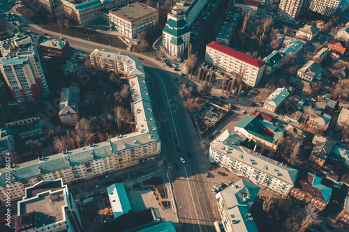 Aerial top down view of road with car traffic among urban high-rise buildings and houses, drone shot of transportation junction in modern city downtown © DedMityay