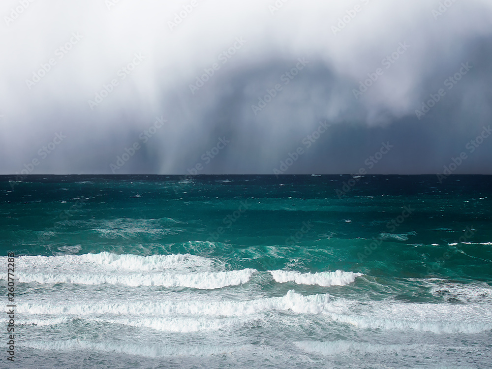 stormy clouds and rain on a sea with waves
