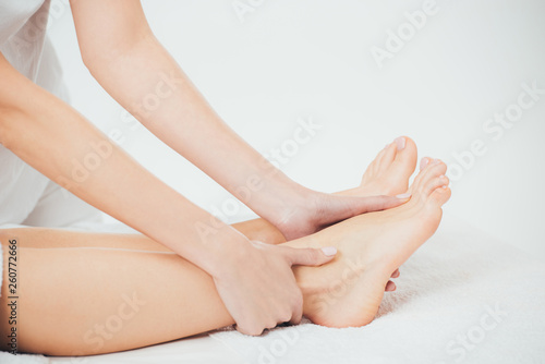 Fototapeta Naklejka Na Ścianę i Meble -  partial view of masseur doing foot massage to adult woman in spa