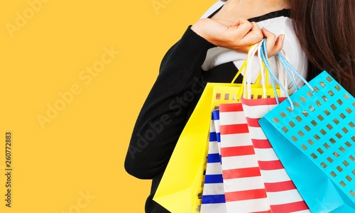 Young woman with shopping bag on background