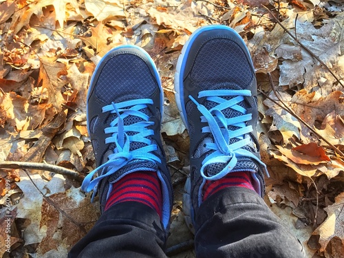 Background of blue shoes with red socks of the traveller in the forest.